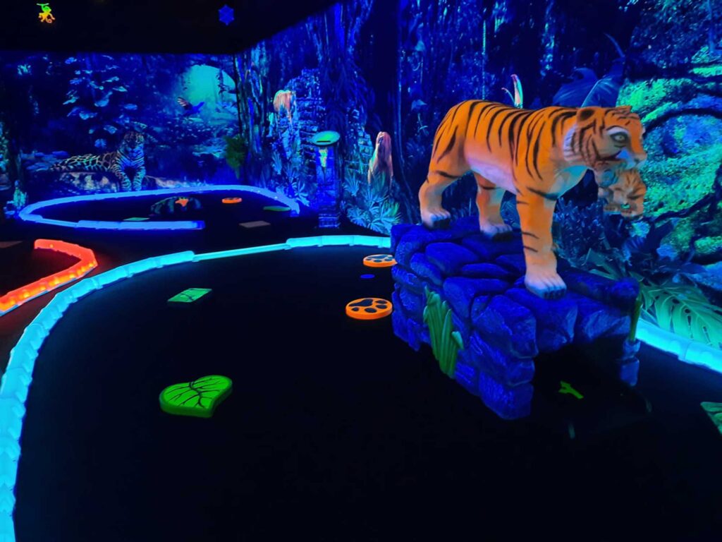 Visiting Rainforest Black Light Golf & Arcade is one of the best indoor things to do in Destin Florida.